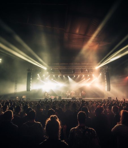 Glowing stage light illuminates cheering rock fans generated by artificial intelligence